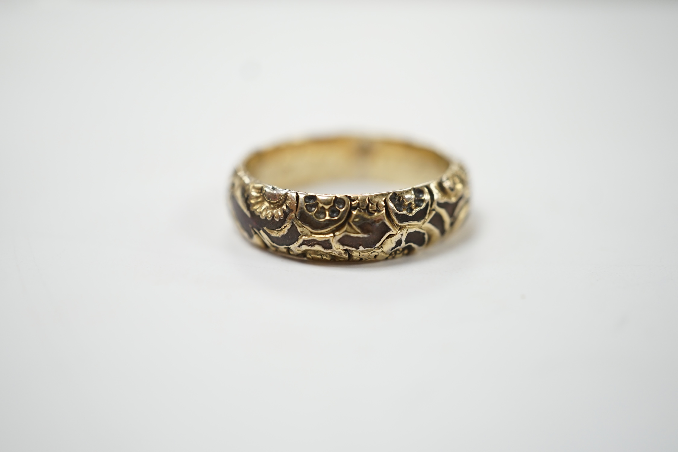 A George IV carved yellow metal and base metal mourning band, with interior engraved inscription, 'Edward Garrett, ob. Feb. 24th, 1827 aged 57', size O/P. Fair condition.